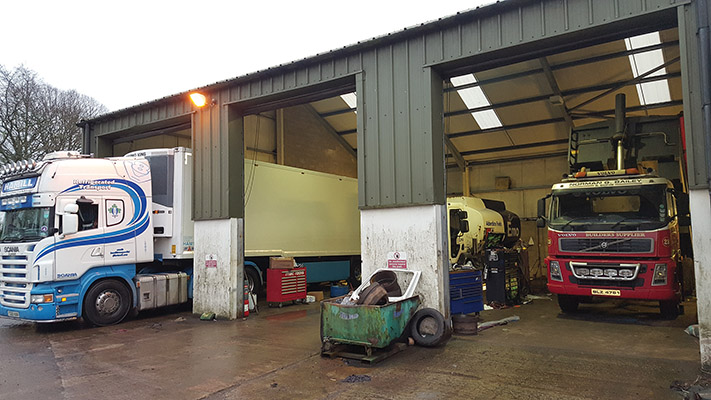 The modern workshop features three bays for commercial vehicles and two for cars)